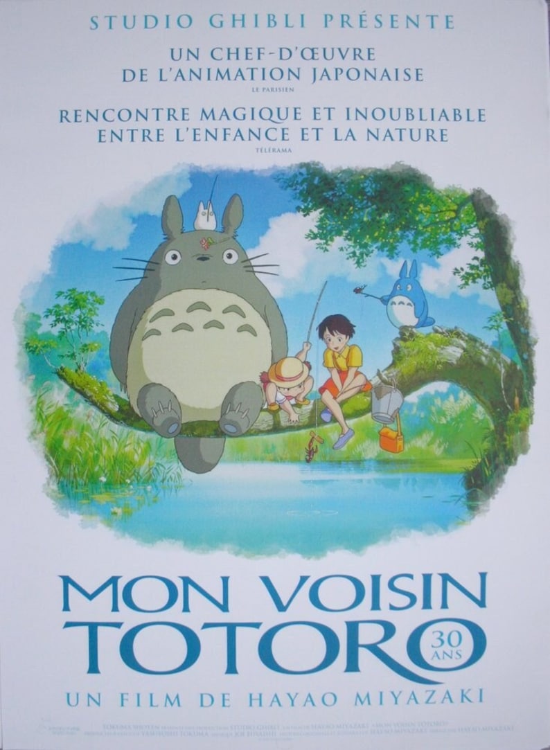 K&ouml;nnte beinhalten: Ein Filmplakat f&uuml;r den Animationsfilm "Mein Nachbar Totoro" mit einer gro&szlig;en, pelzigen, grauen Kreatur mit gro&szlig;en Augen, die auf einem Ast sitzt. Zwei Kinder angeln in einem See unter dem Ast. Das Plakat ist auf Franz&ouml;sisch und enth&auml;lt den Text "Studio Ghibli pr&auml;sentiert" und "Ein Film von Hayao Miyazaki".
