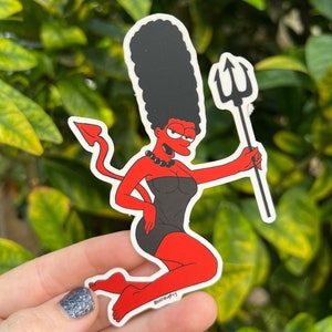 May include: A red cartoon character with a black dress and a devil tail holding a pitchfork. The character has black hair and a mischievous expression.