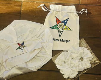 Conjunto de gorro de satén de la Orden de la Estrella de Oriente con coleteros para el cabello y pequeña bolsa de viaje de satén. Talla para adulto.