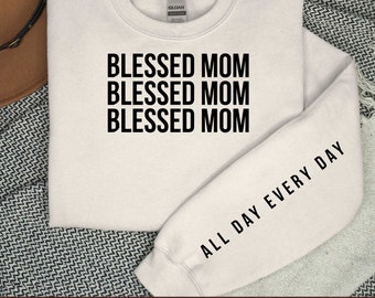 May include: White sweatshirt with the text "Blessed Mom" repeated three times on the front and "All Day Every Day" on the sleeve.