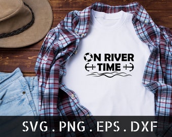May include: White t-shirt with black text that reads "On River Time" with a life preserver, anchors, and wavy lines. The t-shirt is folded and displayed on a plaid shirt and blue jeans.