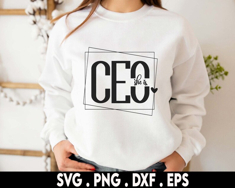 May include: White sweatshirt with black text that reads "CEO she is" inside a black outlined box with a small black heart to the right of the text.