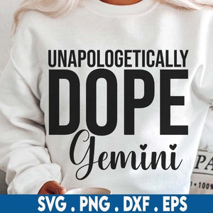 May include: White sweatshirt with black text that reads "Unapologetically Dope Gemini" with a heart symbol on each side of the word Gemini.