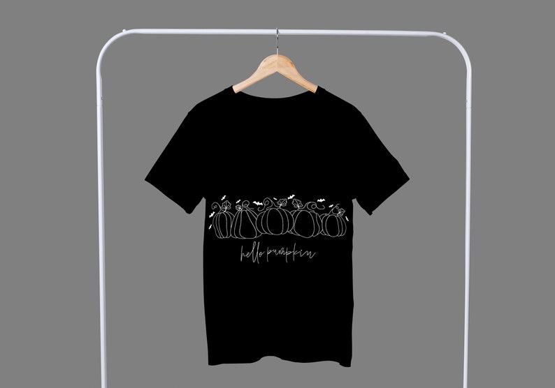 May include: Black t-shirt with a white graphic of pumpkins and the text "hello pumpkin".