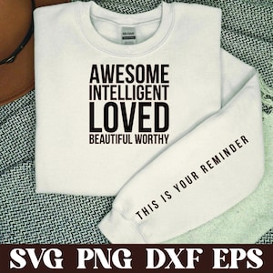 Puede incluir: Sudadera blanca con texto negro que dice "Awesome Intelligent Loved Beautiful Worthy" y "This is your reminder" en la manga.