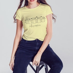 May include: A yellow t-shirt with a black line drawing of pumpkins and the text "hello pumpkin" on the front.