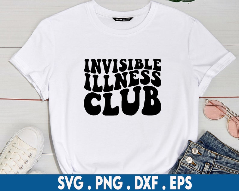 May include: White t-shirt with black text that reads "Invisible Illness Club" in a retro font.