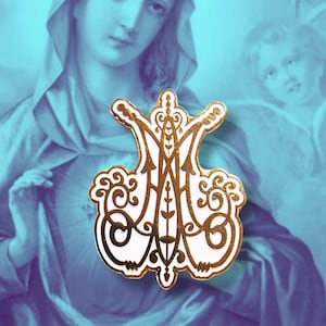 May include: White enamel pin with a gold outline depicting a stylized monogram of the Virgin Mary. The pin features intricate details and a crown at the top.