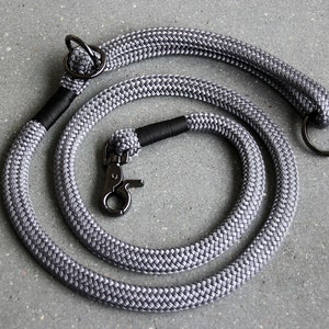 May include: A gray rope dog leash with a black handle and two metal clasps. One clasp is a ring and the other is a hook.