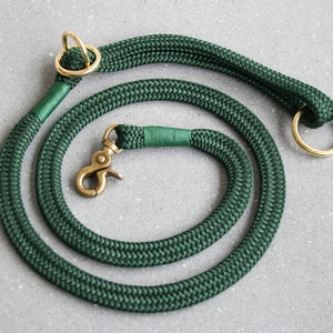 May include: A dark green rope dog leash with brass hardware, including a clip and two rings.