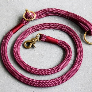 May include: A burgundy rope dog lead with two brass rings and a brass clip.