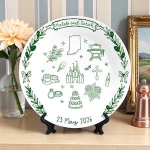 May include: A white ceramic plate featuring green line art illustrations including a castle, a wedding cake, rings, a cross, a grill, a map of Indiana, and coffee cups. The text reads Kaleb and Sarah at the top and 23 May 2026 at the bottom.