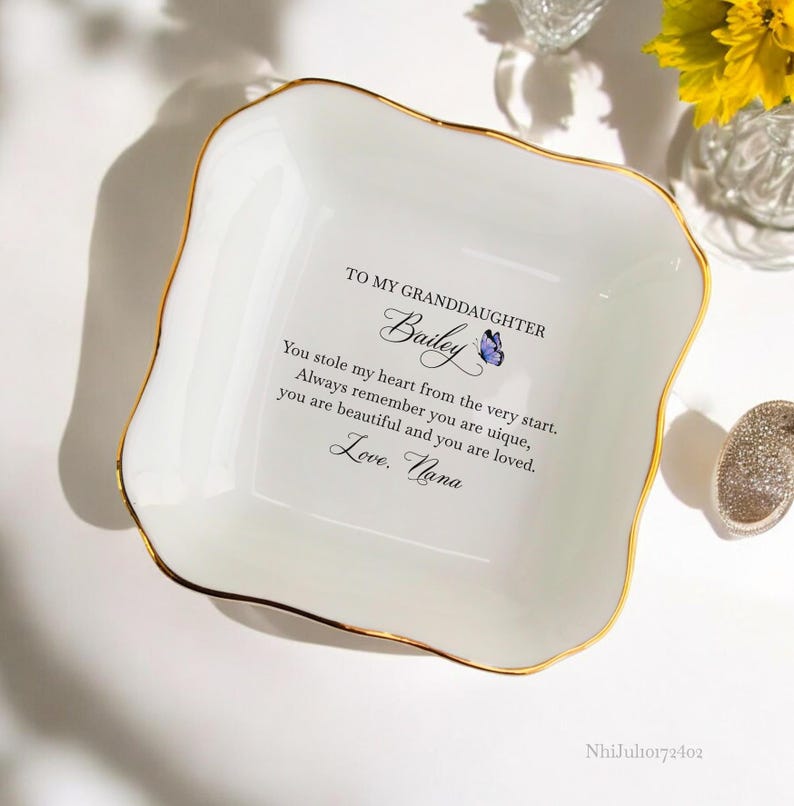 Puede incluir: Plato de cer&aacute;mica blanca para joyas con borde dorado. El plato tiene un mensaje que dice: "A mi nieta Bailey Me robaste el coraz&oacute;n desde el principio. Recuerda siempre que eres &uacute;nica, eres hermosa y eres amada. Con amor. Abuela"