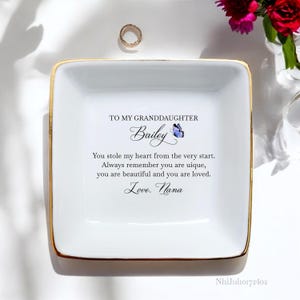 Puede incluir: Plato de cer&aacute;mica blanca para joyas con borde dorado. El plato tiene un mensaje que dice: "A mi nieta Bailey Me robaste el coraz&oacute;n desde el principio. Recuerda siempre que eres &uacute;nica, eres hermosa y eres amada. Con amor. Abuela"
