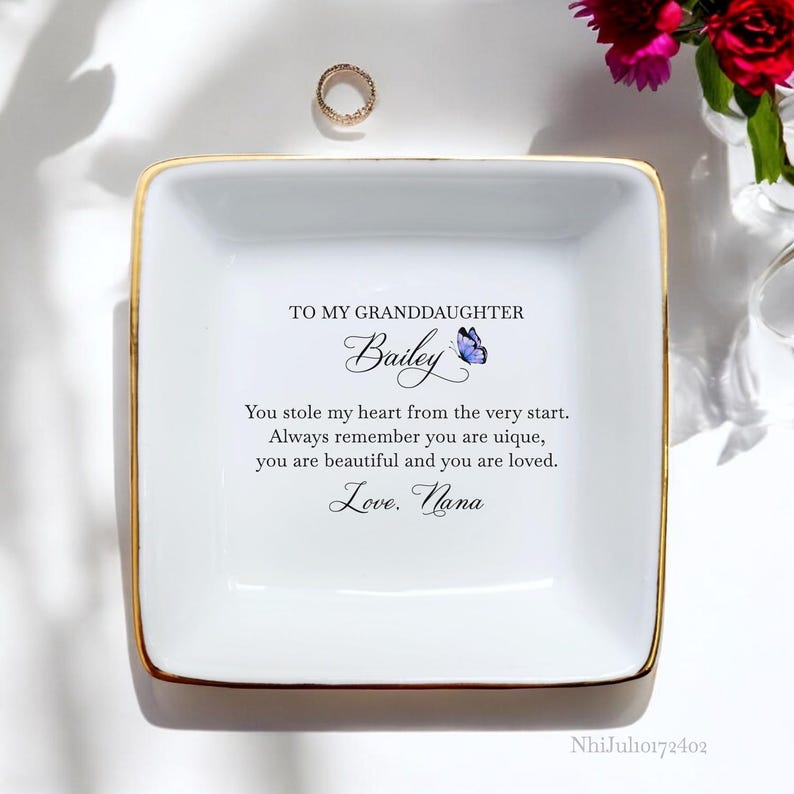 Puede incluir: Plato de cer&aacute;mica blanca para joyas con borde dorado. El plato tiene un mensaje que dice: "A mi nieta Bailey Me robaste el coraz&oacute;n desde el principio. Recuerda siempre que eres &uacute;nica, eres hermosa y eres amada. Con amor. Abuela"