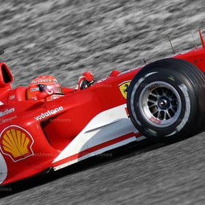 Könnte beinhalten: Ein roter Formel-1-Rennwagen mit den Worten "Marlboro" und "Vodafone" an der Seite. Das Auto befindet sich auf einer Rennstrecke.