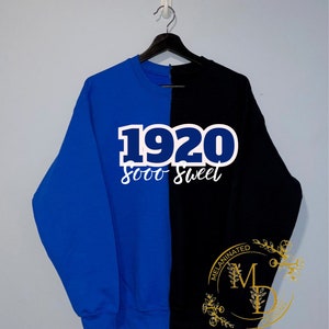 May include: A blue and black sweatshirt with the text "1920 sooo sweet" in white on the blue side. The black side has a gold logo that says "MelaninAted Designs".