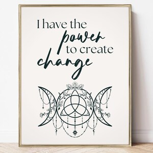 Può includere: Stampa incorniciata con la scritta "I have the power to create change" in verde scuro. Sotto, un'illustrazione decorativa del simbolo della triplice luna con dettagli floreali e di perline, in una cornice dorata.
