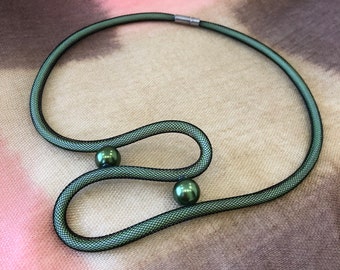 Cadeau. Tube en maille de nylon vert élégant et élégant fait à la main, tour de cou en perles, collier, bijoux de luxe, bijoux populaires. Conception inhabituelle