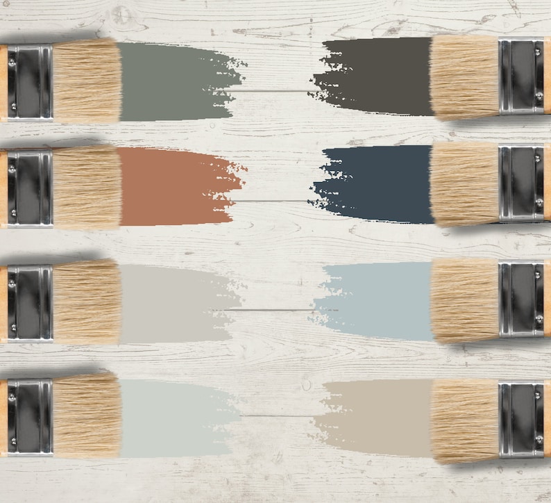 May include: Eight paintbrushes with wooden handles and natural bristles are arranged on a white wooden surface. Each brush displays a swatch of paint in a different color, including shades of green, brown, blue, and beige. The image showcases a color palette.