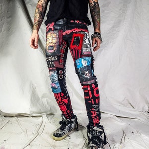 Model showing a skinny custom made black pair with prints containing various horror movies, red and black patchwork, abstract painting, studs, red laces hanging down, chain and eyelets.
