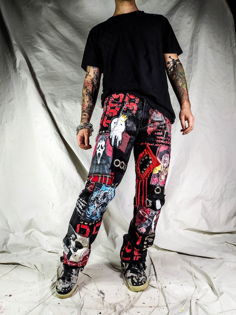 Model showing a custom made black pair with prints containing various horror movies, red and black patchwork, abstract painting, studs, red laces hanging down, chain and eyelets.