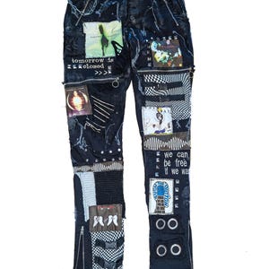 May include: Black denim pants featuring a distressed paint splatter effect, multiple graphic patches, metal studs, zippers, and buckle straps. Text includes "tomorrow is closed", "we can be free if we want", and "push the button" with various imagery.