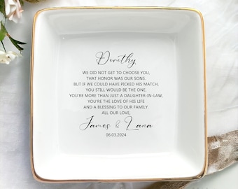 May include: White ceramic square dish with a gold rim. The dish has a message inscribed on it that reads: "Dorothy, We did not get to choose you, that honor was our sons. But if we could have picked his match, you still would be the one. You're more than just a daughter-in-law, you're the love of his life and a blessing to our family. All our love, James & Lana 06.03.2024"
