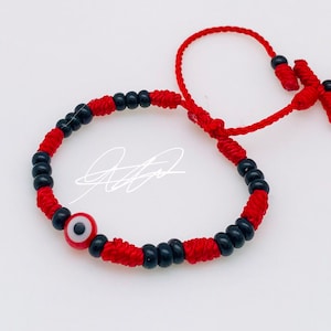 Pulsera roja con ojo turco color y cuentas negras tiene una cruz es Para niños/Niñas