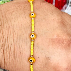 Pulsera amarilla con 6 ojitos  y chaquiras