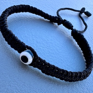 Pulsera negra con ojo turco color negro tejida con hilo espiga # 9 ajustable para hombre o mujer excelente regalo para alguien muy especial