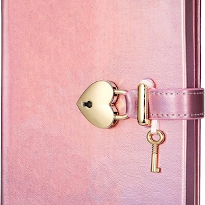 May include: A pink journal with a heart-shaped lock and key. The journal has a textured cover and a strap closure. The lock and key are gold-colored, adding a touch of elegance to the design. The journal's pages are not visible.