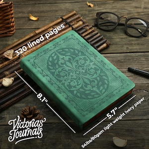 May include: Green journal with an embossed floral design. The journal has 320 lined pages and measures 20.6cm x 14.5cm. The paper is 54lbs/80gsm light weight ivory. The journal is branded "Victorias Journals".