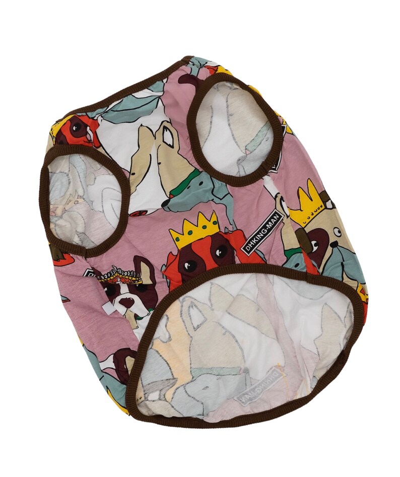 May include: A pink dog vest with a brown trim and a multi-colored print of cartoon dogs. The vest has the text "DHKING-MAN" printed on it.