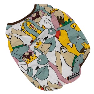 May include: White dog shirt with a colorful print of dogs wearing crowns. The shirt has a brown trim around the neck and the text "DHKING-MAN" is printed on the bottom right corner.