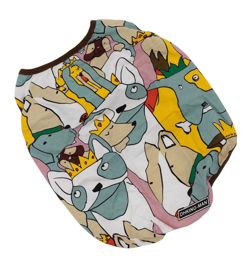 May include: White dog shirt with a colorful print of dogs wearing crowns. The shirt has a brown trim around the neck and the text "DHKING-MAN" is printed on the bottom right corner.