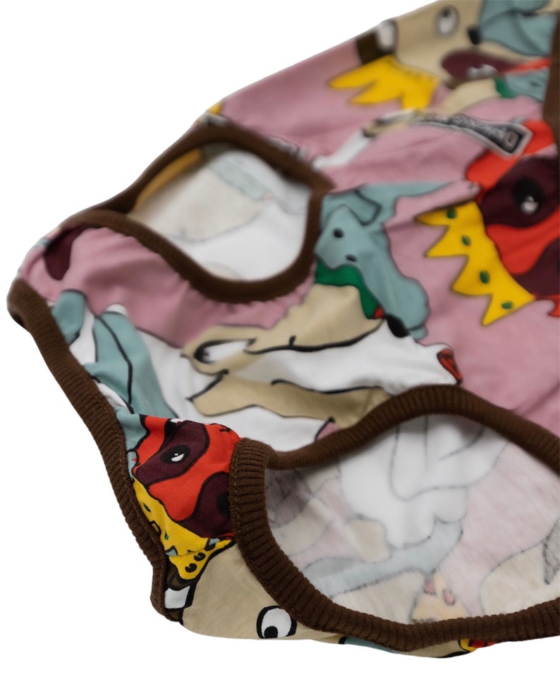 May include: Pink underwear with a brown trim and a colorful cartoon print of dogs wearing crowns.