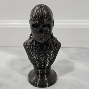 Puede incluir: Un busto de cráneo impreso en 3D en blanco y negro con una superficie texturizada.