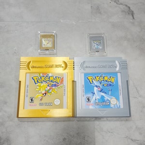 May include: Two Nintendo Game Boy cartridges, one gold and one silver, with the Pokemon logo and game titles "Gold Version" and "Silver Version".