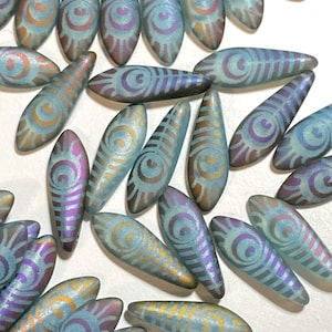 May include: A collection of iridescent blue glass beads with a swirling pattern. The beads are shaped like teardrops and have a metallic sheen.