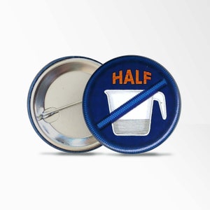 May include: A blue and white button with a white measuring cup with a diagonal red line through it and the word "HALF" in orange text.