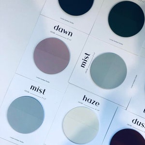 Op de afbeelding: Zes ronde stickers met verschillende kleuren en namen: aarde, dageraad, mist, mist, waas, stof. Elke sticker heeft een diameter van 5 cm.