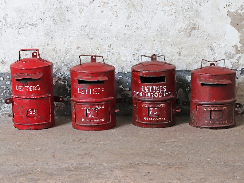 May include: Four red vintage mailboxes with white lettering. The mailboxes have a slot for letters and a small door on the bottom. The mailboxes are labeled "Letters", "Letters", "Letters PN-147001", and "Letters".