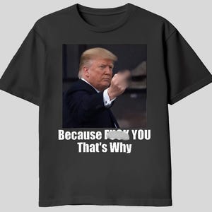 May include: Black t-shirt featuring a photo of a man in a suit gesturing with his hand. The text "Because F*** YOU That's Why" is printed in white below the photo. The shirt is a casual wear item.