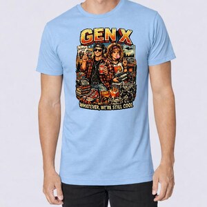 Puede incluir: Camiseta azul claro con un dise&ntilde;o gr&aacute;fico colorido. El dise&ntilde;o presenta el texto "GEN X" en naranja y amarillo, y dos figuras con objetos retro. Tambi&eacute;n est&aacute; presente el texto "Whatever, we're still cool".