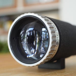 Puede incluir: Un objetivo de c&aacute;mara plateado y negro con el texto "Leitz Wetzlar" inscrito en el lateral.