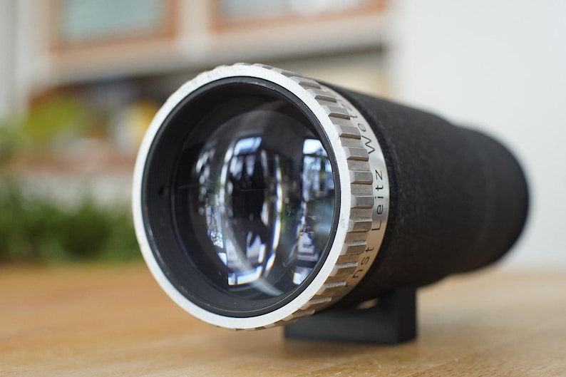 Puede incluir: Un objetivo de c&aacute;mara plateado y negro con el texto "Leitz Wetzlar" inscrito en el lateral.