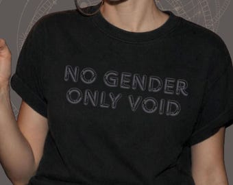 Puede incluir: Una camiseta negra de manga corta con el texto NO GENDER ONLY VOID en una fuente desgastada. La camiseta tiene cuello redondo y mangas remangadas. Se lleva un cinturón negro con una gran hebilla rectangular de metal color latón en la cintura.