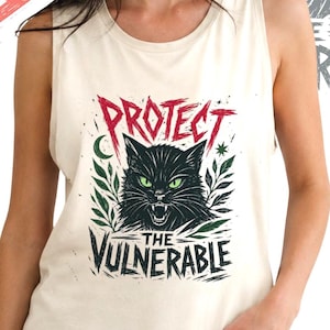 Puede incluir: Una camiseta sin mangas de color crema con un estampado gráfico de un gato negro con ojos verdes, rodeado de follaje y el texto "PROTECT THE VULNERABLE" en rojo y negro, acompañado de iconos de rayos rojos en el lateral.