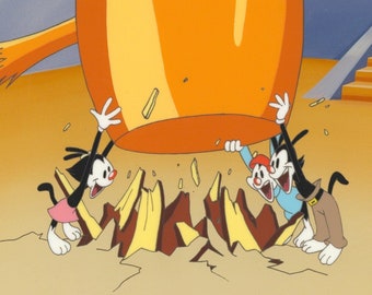 May include: Three cartoon cats in a yellow and orange room. The cats are wearing clothes and are holding onto a large orange object. The object is falling and breaking apart into pieces.